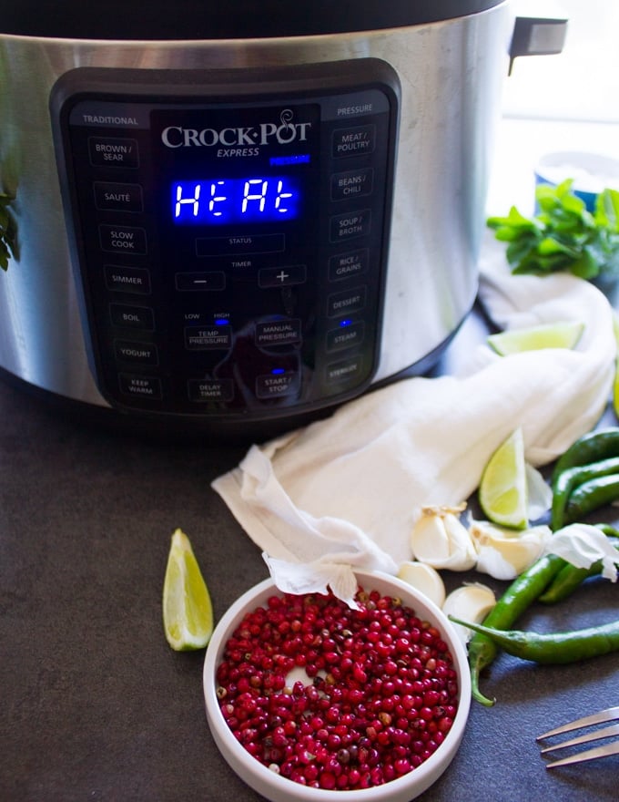 An instant pot or crock-pot turned on to cook the potatoes faster