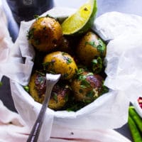 Pan fried potatoes served in a small bucket with a lime wedge