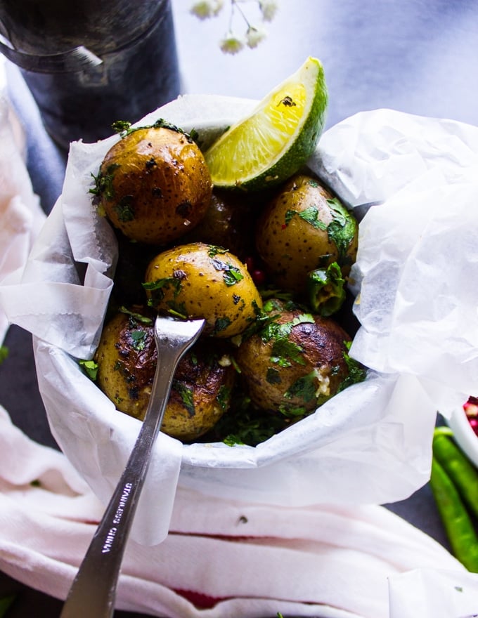 Pan fried potatoes served in a small bucket with a lime wedge