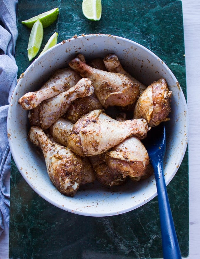 chicken legs coated with the dry spice mix in a bowl