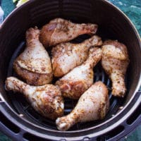 chicken legs coated with the spice mix and placed in an air fryer basket ready to air fry