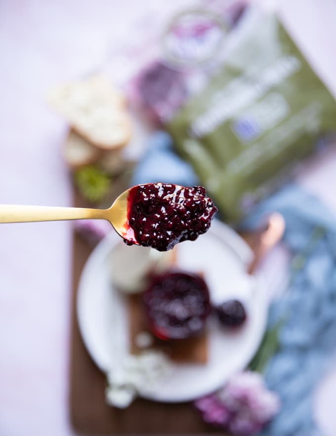 A spoon holding a finished jam ready for the freezer or fridge