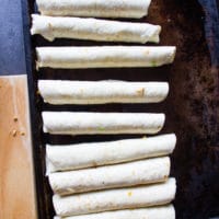 rolled out chicken flautas on an oiled baking sheet ready to go in to the oven