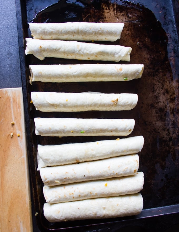 rolled out chicken flautas on an oiled baking sheet ready to go in to the oven