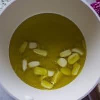 Sliced garlic in olive oil going to cook on the stove