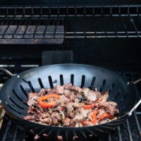 showing option for the BBQ using a perforated grill pan with the meat and veggies mixture in the pan over the grill for the philly cheesesteak sliders