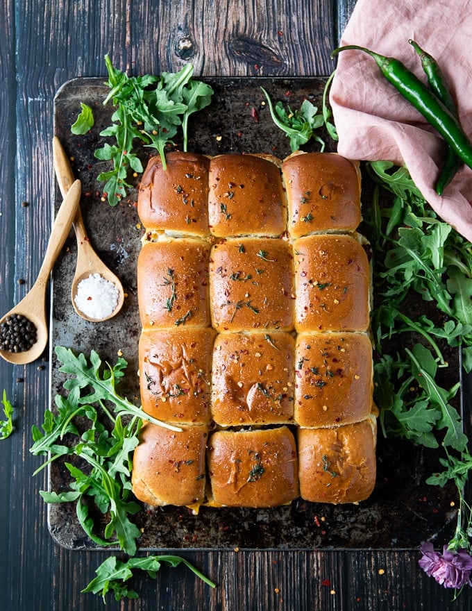 Plated Philly Cheesesteak sliders on a metal plate with arugula around it