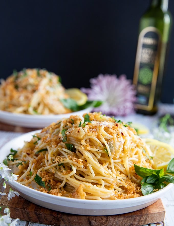 close up of the spaghetti aglio e olio dish showing the crunchy bread crumbs and fresh basil with sliced cooked garlic and olive oil