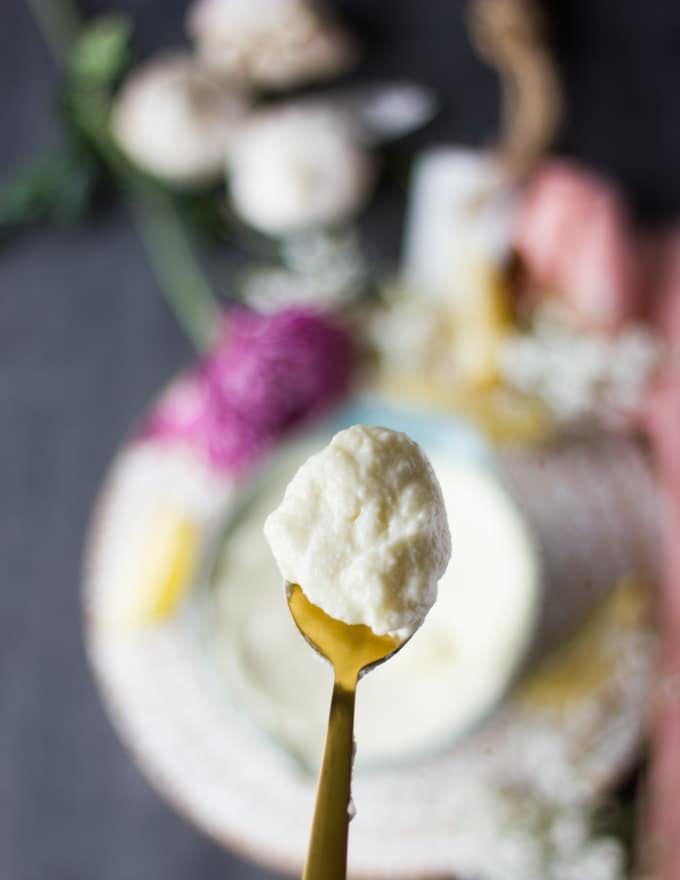 a close up spoonfull of creamy garlic sauce or toum showing the final texture