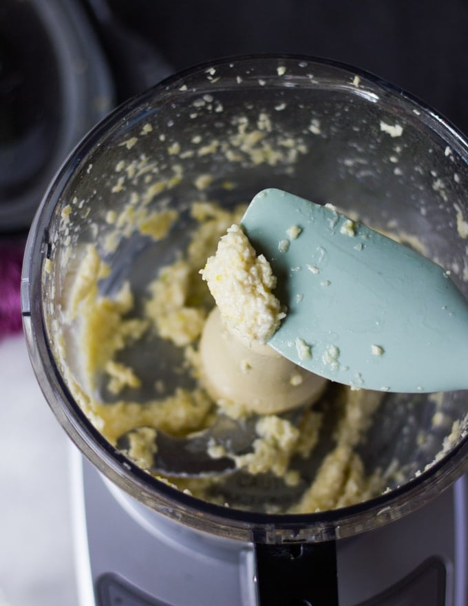 A spatula showing the consistency of the garlic and salt minced well before proceeding with the garlic sauce recipe