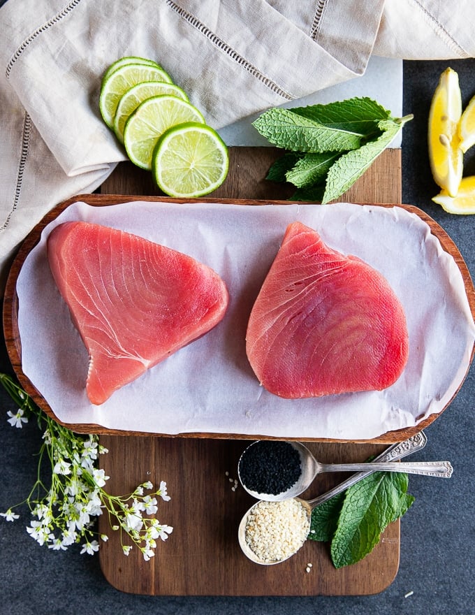 two tuna steaks on a parchment paper showing the fresh ahi tuna