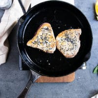 tuna steak recipe flipped in a cast iron pan after being golden on one side