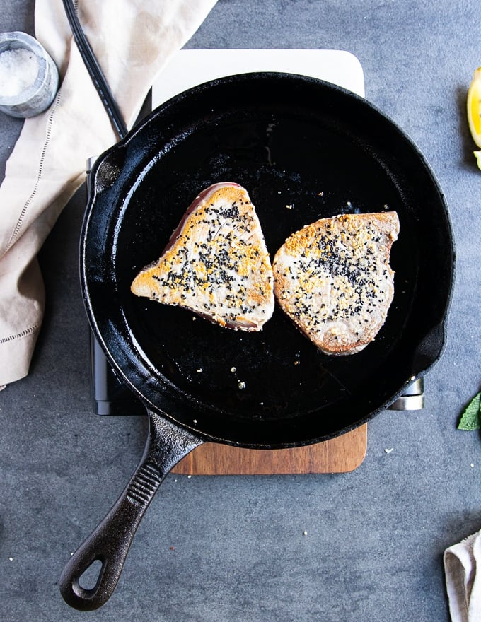 tuna steak recipe flipped in a cast iron pan after being golden on one side