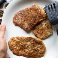 The veal pieces are removed on to a white plate as tthe pan will be used to make the sauce now