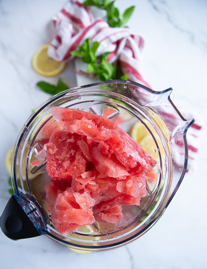 frozen ice cube chunks in a blender bowl ready to make a slush