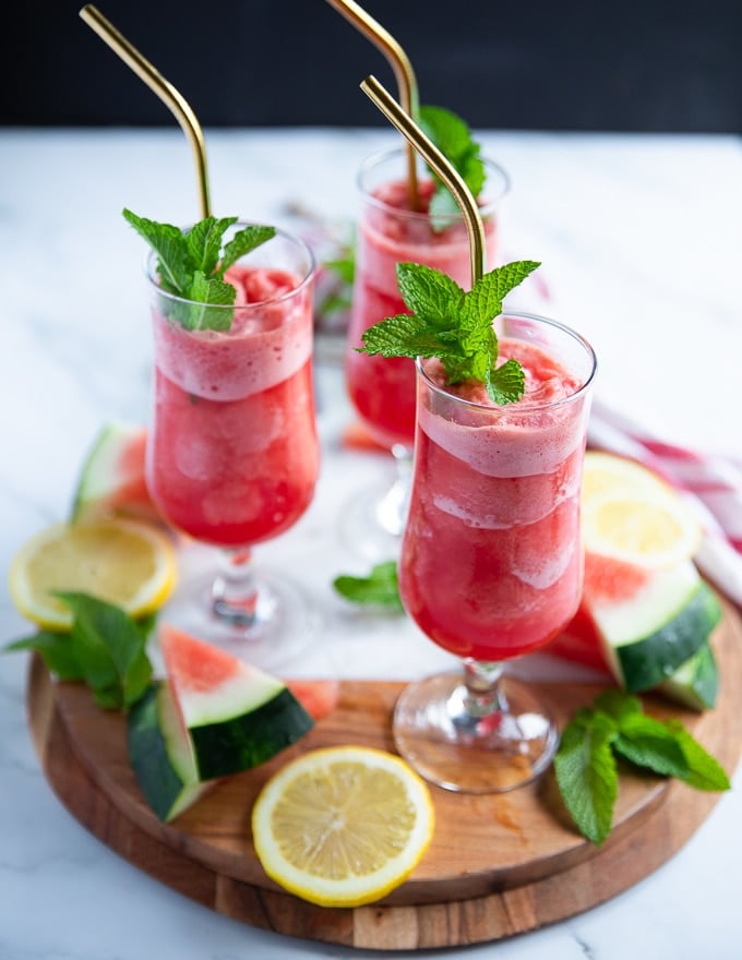 summer watermelon slish in a cup that's starting to melt and showing the cold refreshing melted layer at the bottom with a more frozen top