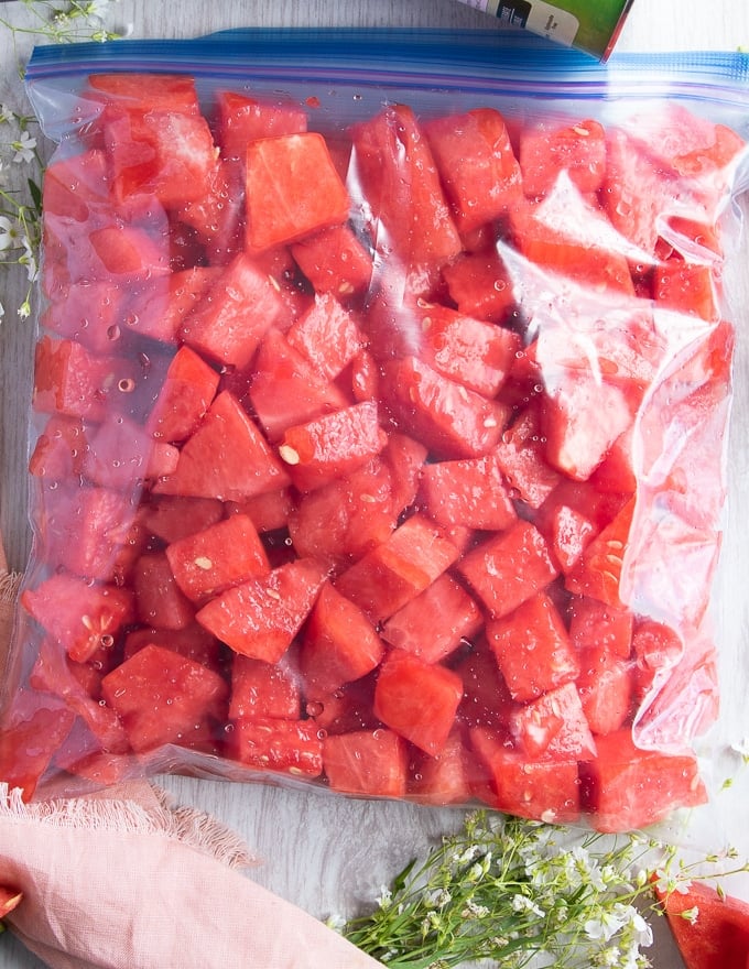 watermelon cubes placed in a ziploc bag and ready to freeze 