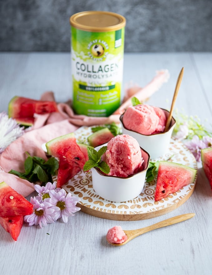 two bowls of the watermelon sorbet recipe and two wooden spoons scooping out some sorbet to show the texture 