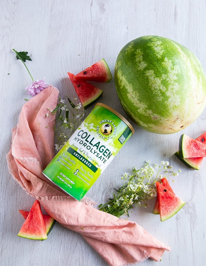 A box of collagen which is boosting the sorbet recipe and a large watermelon next to it on a white board 