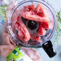 the frozen watermelon chunks going in a food processor and ready to blitz into a sorbet