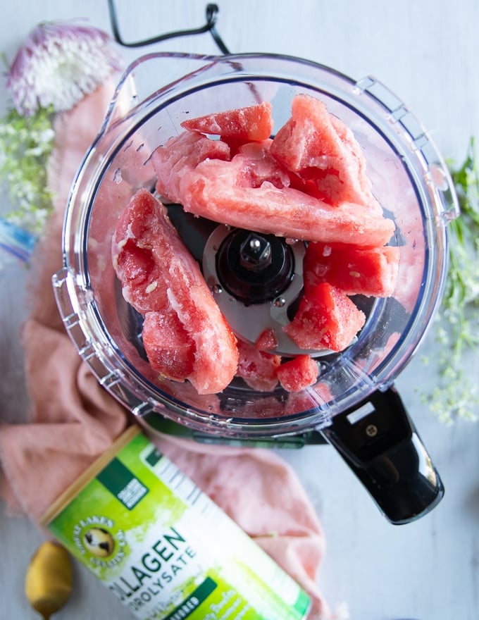 the frozen watermelon chunks going in a food processor and ready to blitz into a sorbet