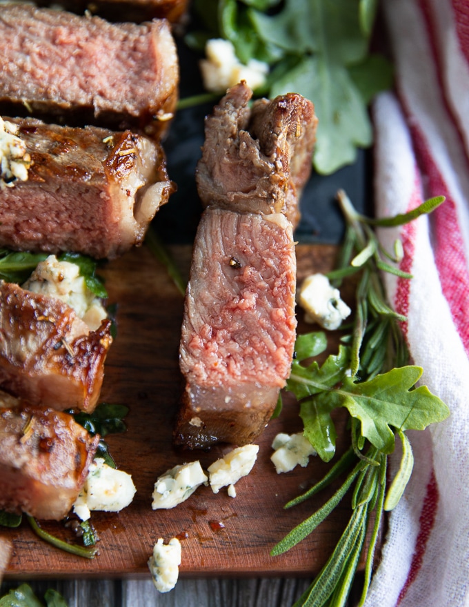 a small pice of NY strip close up surrounded by blue cheese crumbles