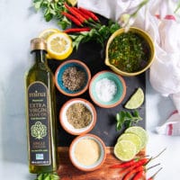 ingredients for chicken chimichurri including chimichurri recipe, spices to season the chicken and olive oil