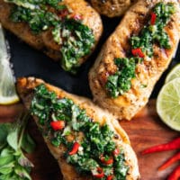 close up of three pieces of chicken chimichurri drenched with chimichurri sauce