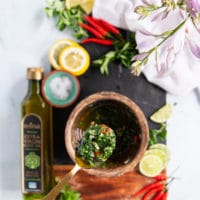 A spoon holding off some chimichurri sauce showing off the final texture and sauce