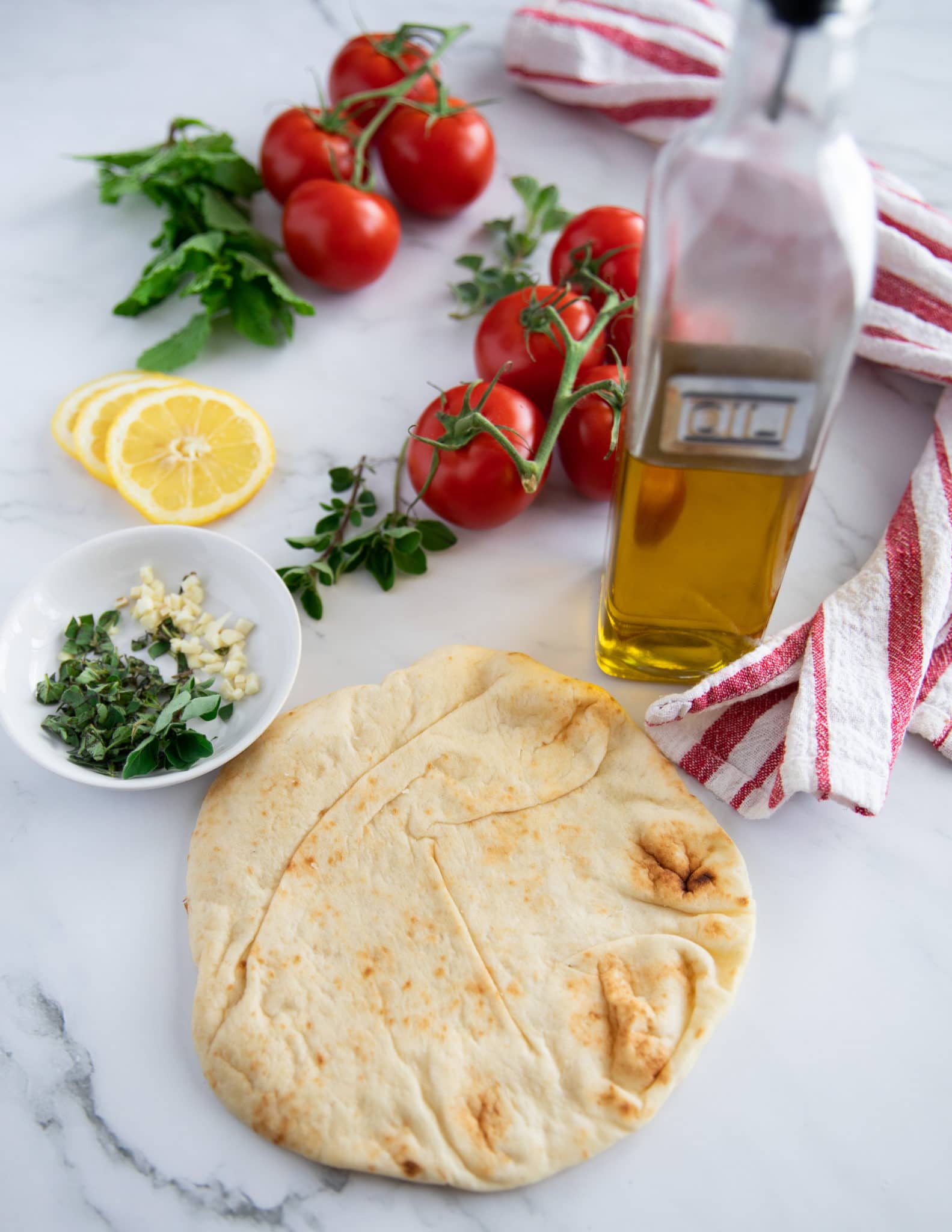 ingredients for crunchy bread to go in the salad including thick pita bread, olive oil, garlic and fresh oregano