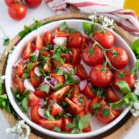 thinly sliced shallots and fresh herbs are added over the tomatoes