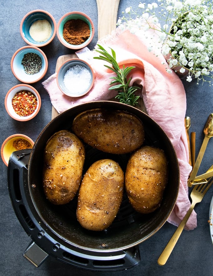 Seasoned Russet Potatoes in an air fryer basket ready to air fry