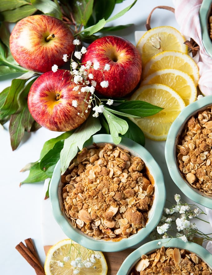 close up of a baked apple crumble showing the crisp crumble topping surrpunded by apples and lemon slices