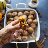 a hand holding the tossed pumpkin donut recipe showing inside of the donut