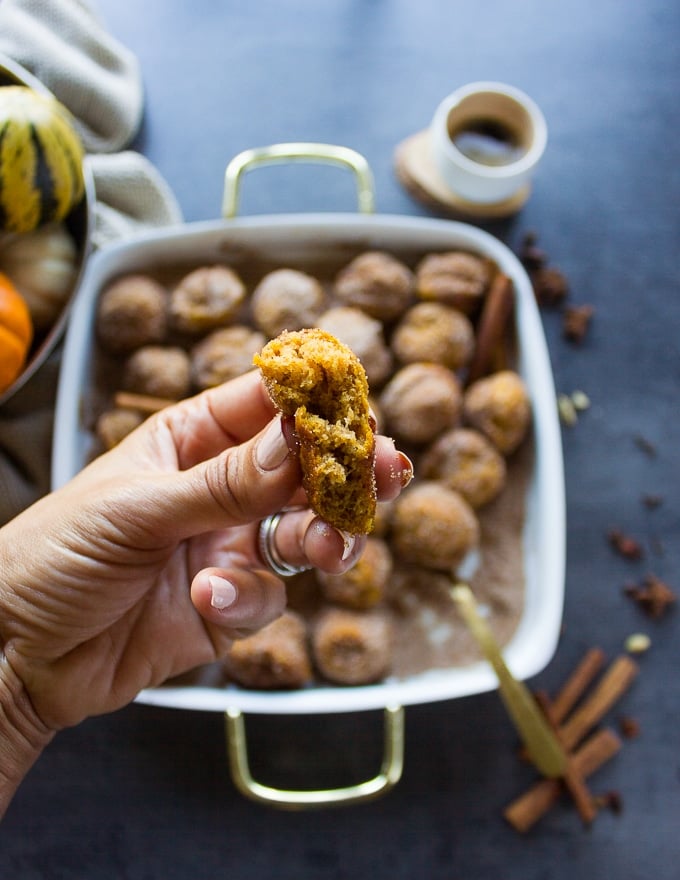 a hand holding the tossed pumpkin donut recipe showing inside of the donut