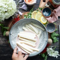 A hand pouring the sliced halloumi cheese into the flour bowl