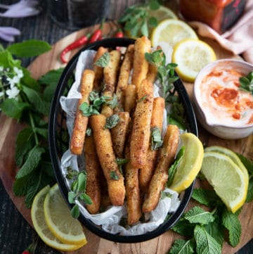 A basket of halloumi fries served with a squeeze of lemon juice and fresh mint