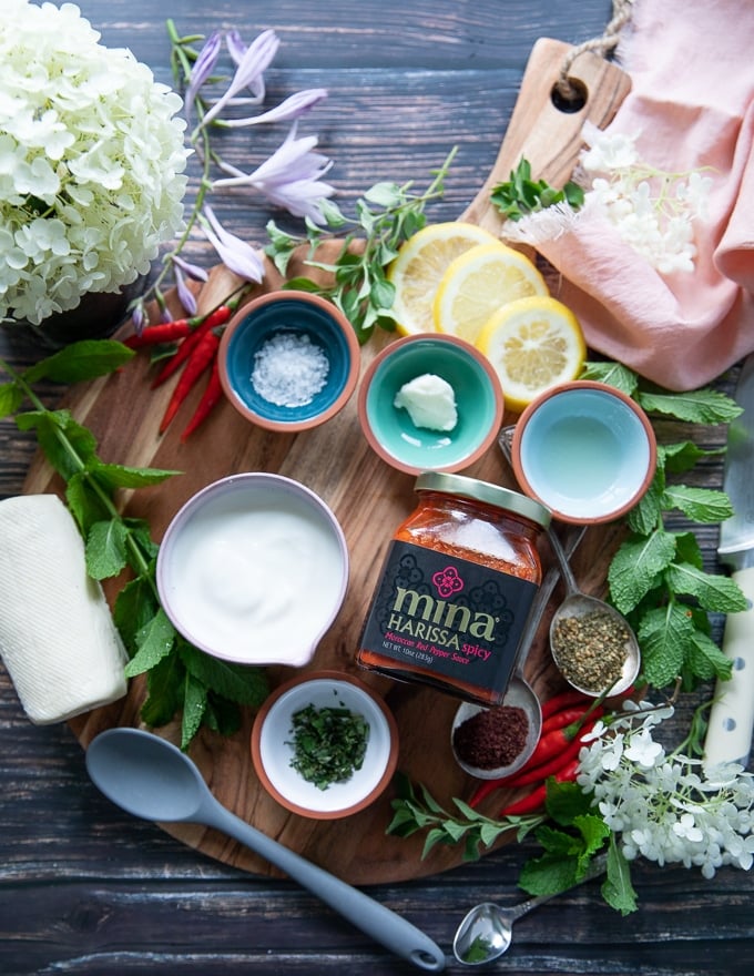 ingredients for the yogurt dipping sauce including yogurt, garlic paste, harissa sauce, salt, herbs, sumac and lemon juice