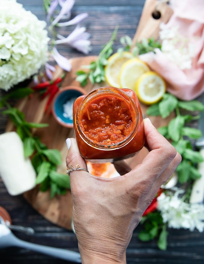 An open jar of harissa showing the inside of the jar and the texture of the sauce