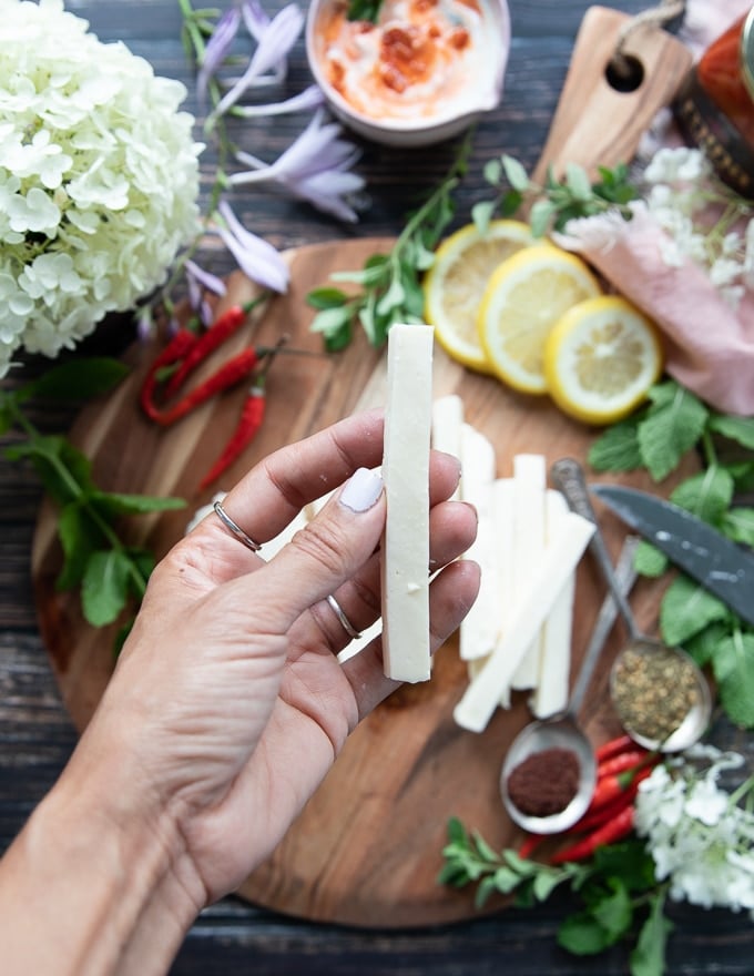 a hand holding a halloumi shaped fries