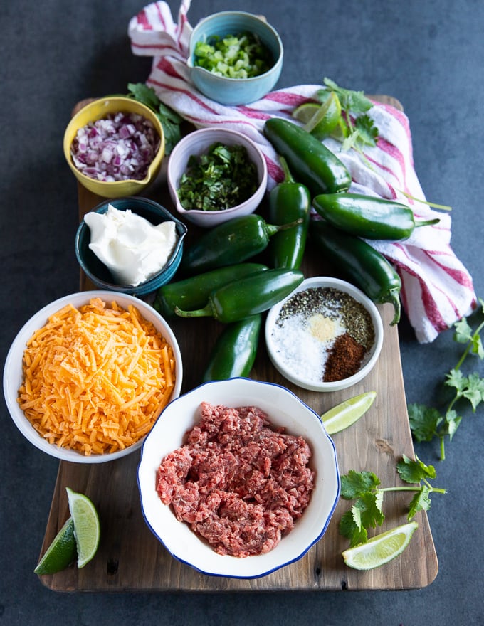 ingredients to make jalapeno poppers recipe including jalapeños , Cheese , onions , Spices , cream cheese , cilantro and ground Lamb.