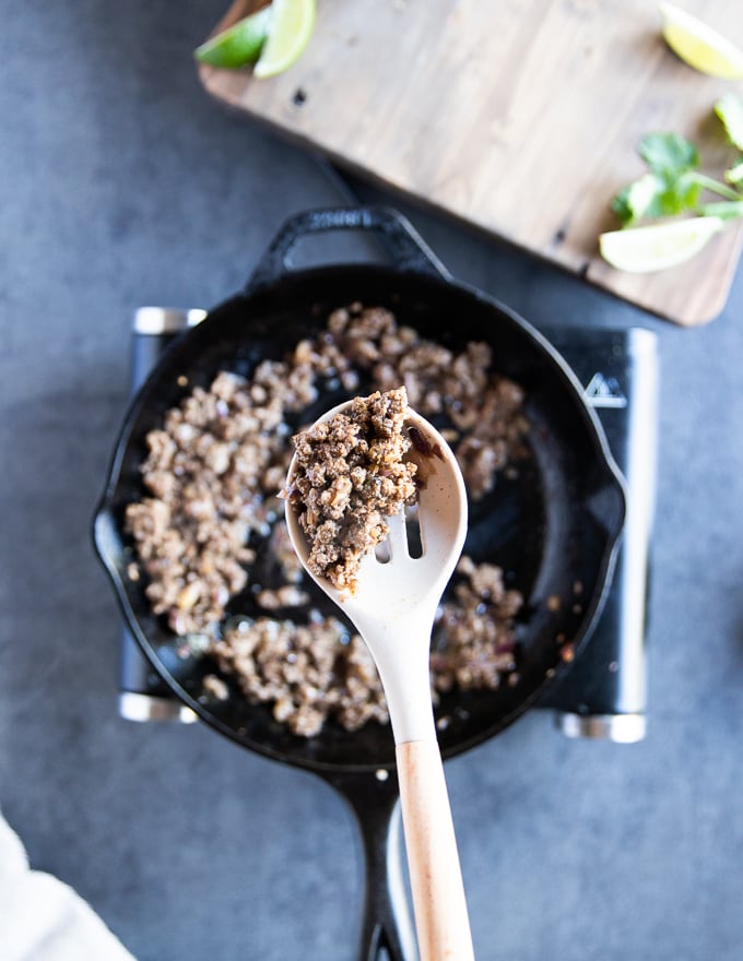 Fully cooked lamb mixture, a slotted spoon holding off the lamb to show the cooked meat