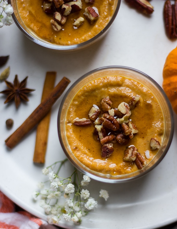close up of pumpkin pudding serving topped with roasted nuts.
