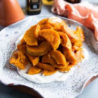 The roasted honeynut squash is added over the yogurt sauce