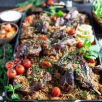 A plate of lamb shoulder chops cooked with rice and served for a one pot meal