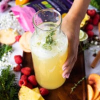 mixing together the ingredients for the pineapple mojitos all ready in a jar