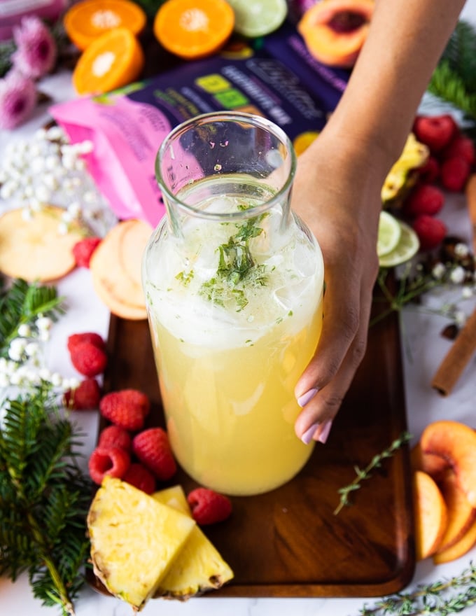 mixing together the ingredients for the pineapple mojitos all ready in a jar