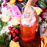 mixed up and ready peach bellini mocktail with fresh raspberries and fresh peaches ready to serve
