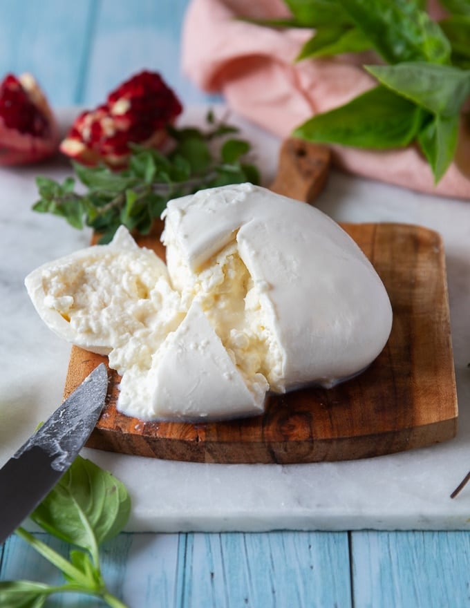 burrata cheese sliced to show the inside of the cheese and the creamy inside filling of burrata cheese