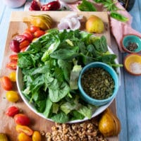 ingredients for the simple salad includes greens, fresh pears, tomatoes, nuts, seeds, shallots and fresh herbs